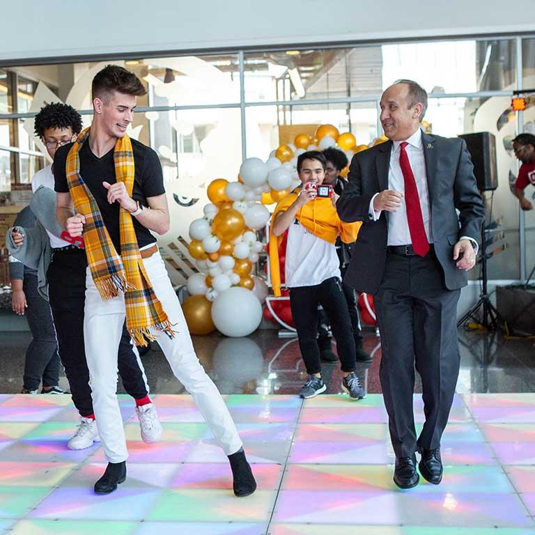 Chancellor Paydar and some students dance.